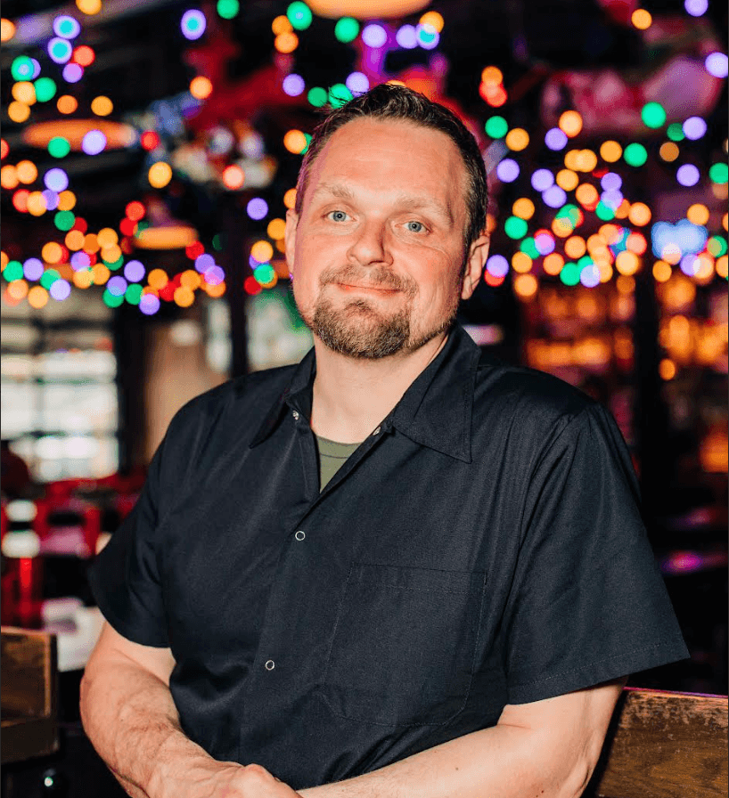 man at bbq restaurant with twinkling lights