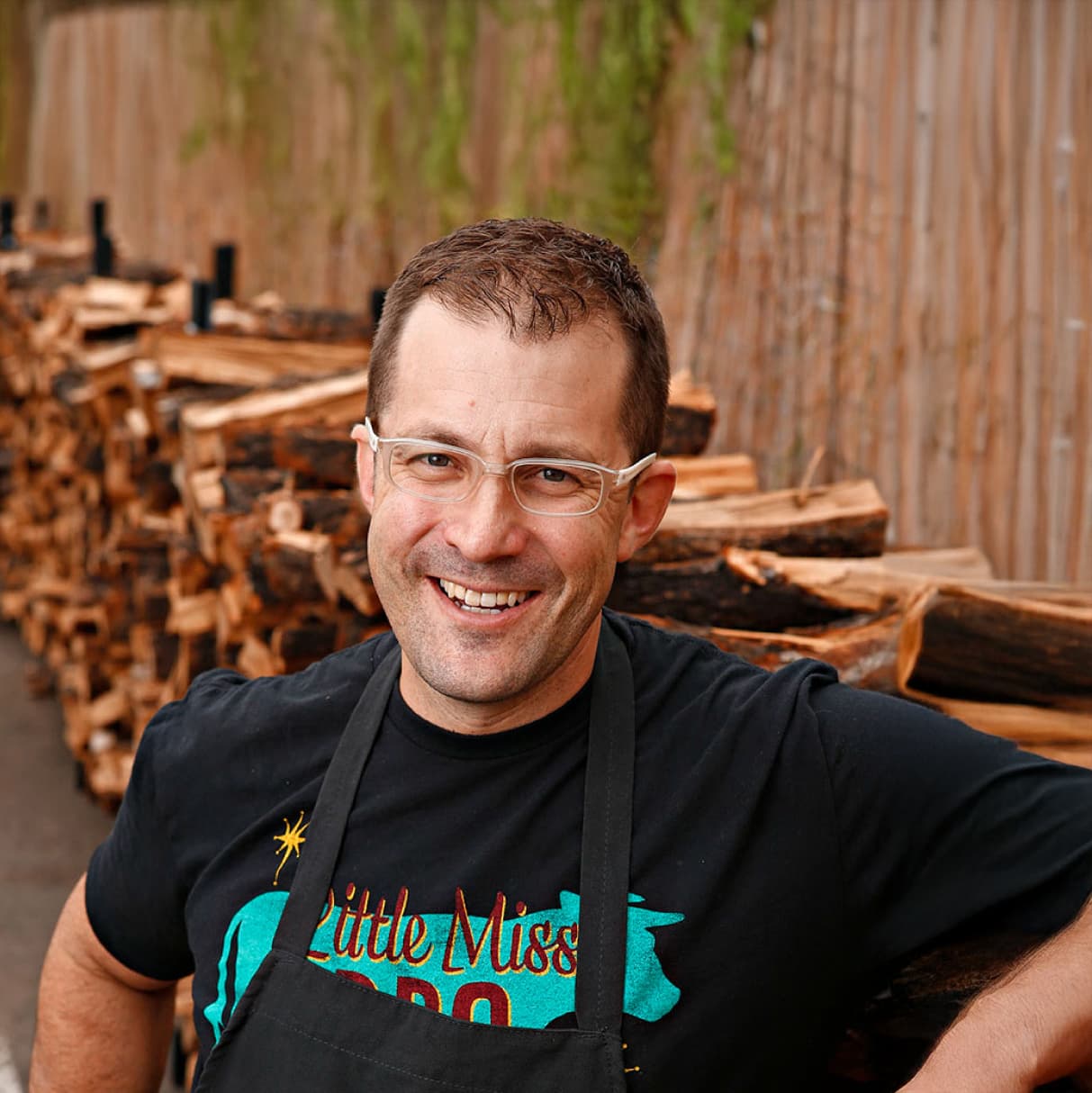 man in front of chopped wood