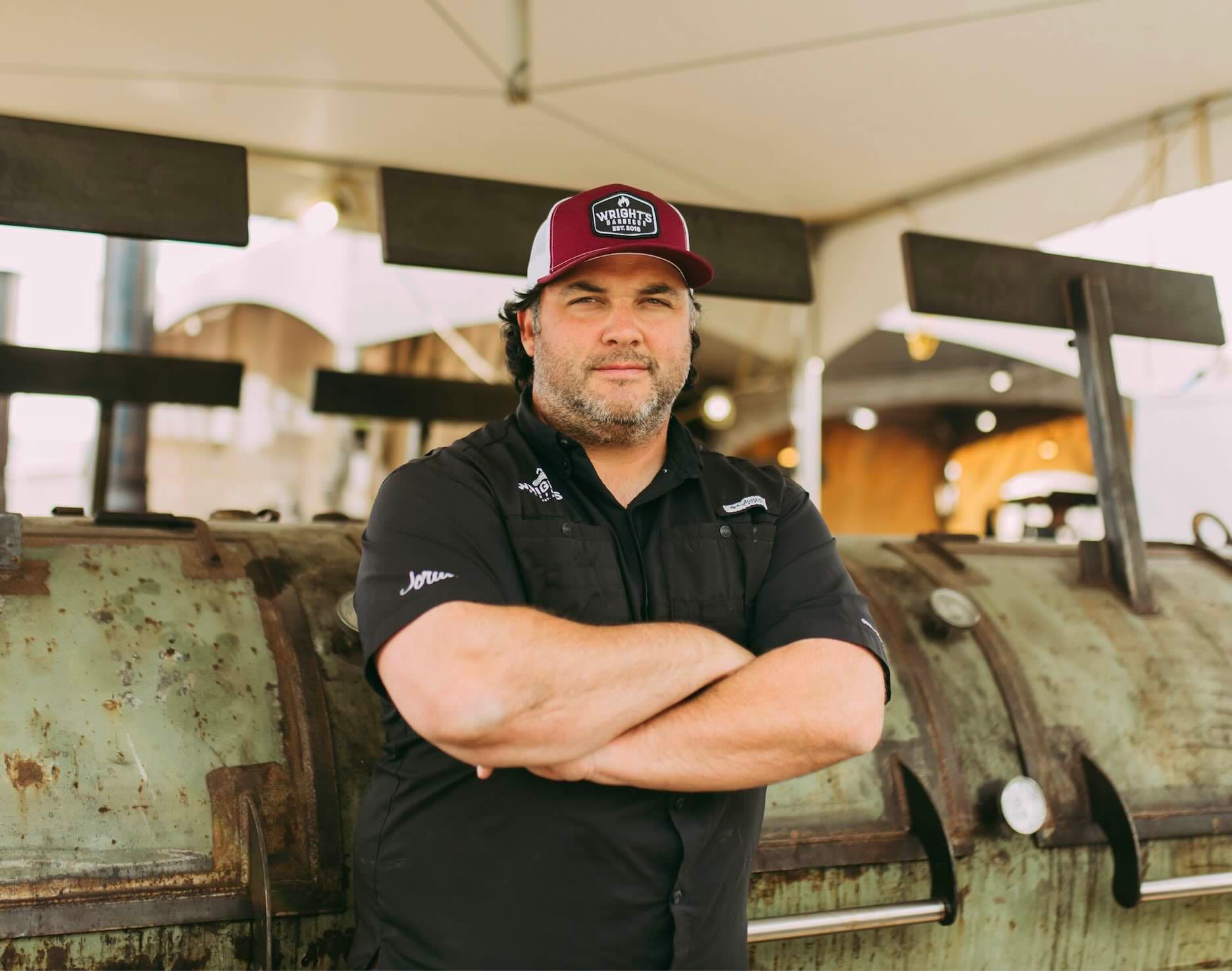 man in front of bbq smoker