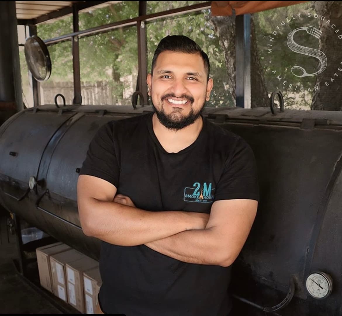 man in front of bbq smoker
