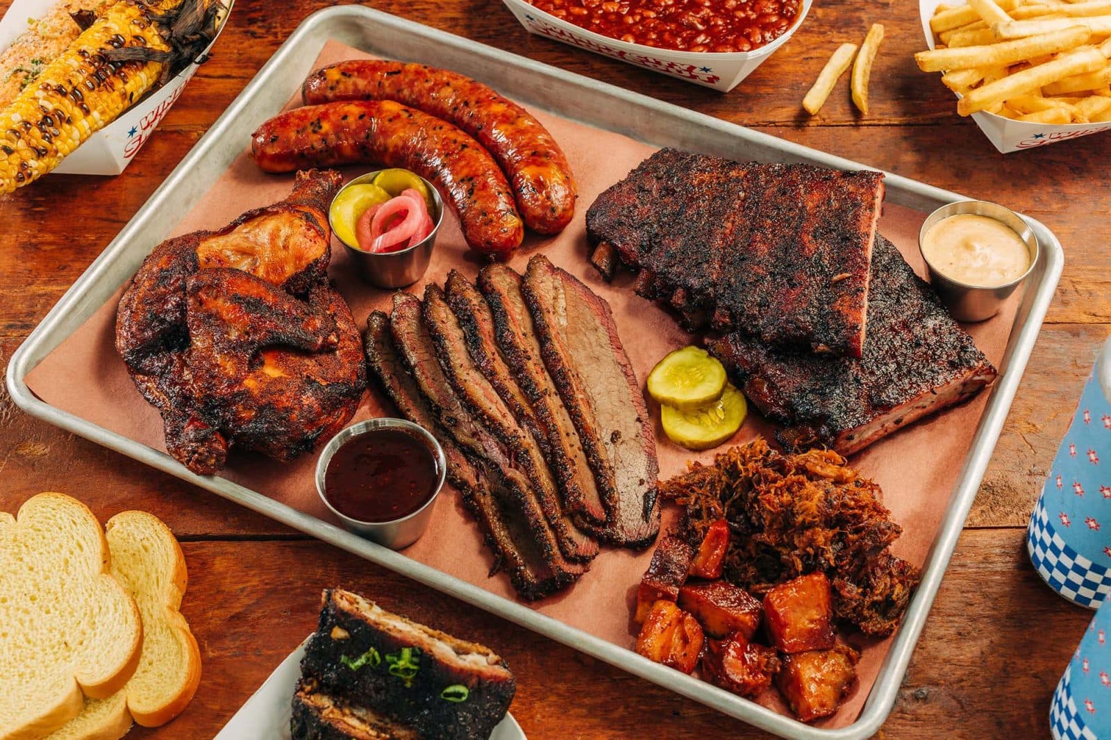 a tray of bbq meats including ribs, smoked sausage and chicken